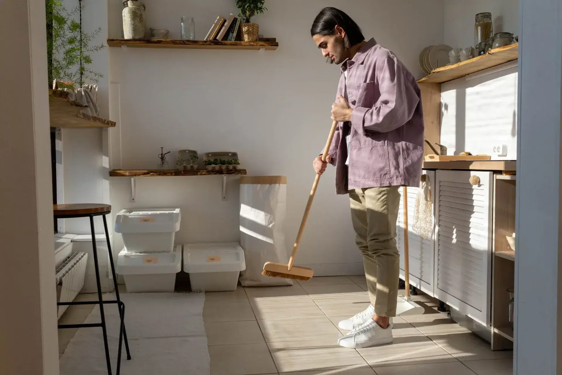 Man sweeping modern kitchen floor
