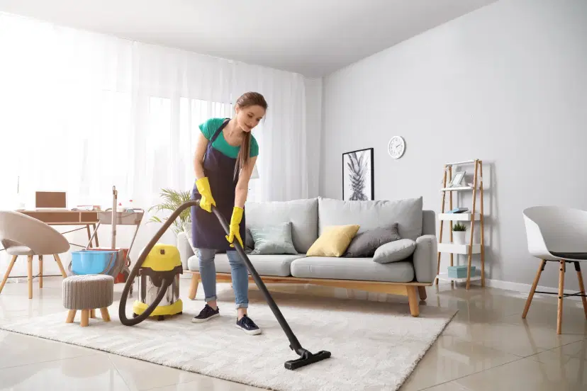 Woman vacuuming living room carpet
