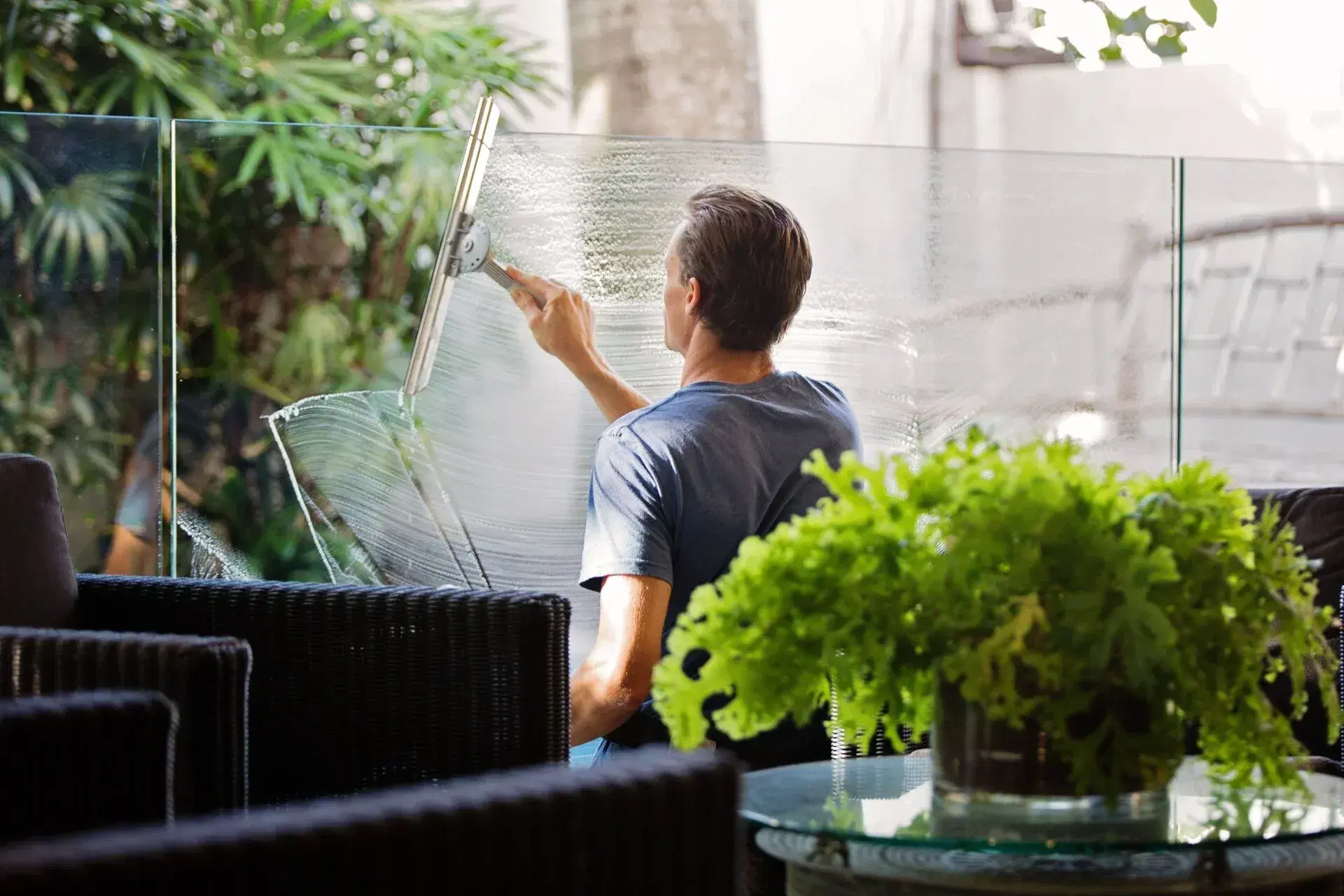 Man cleaning glass window with squeegee