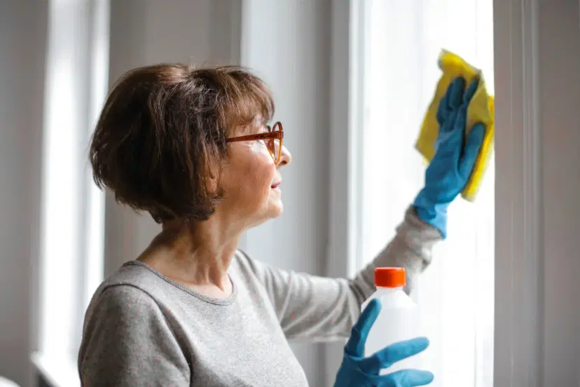 Woman cleaning window with squeegee