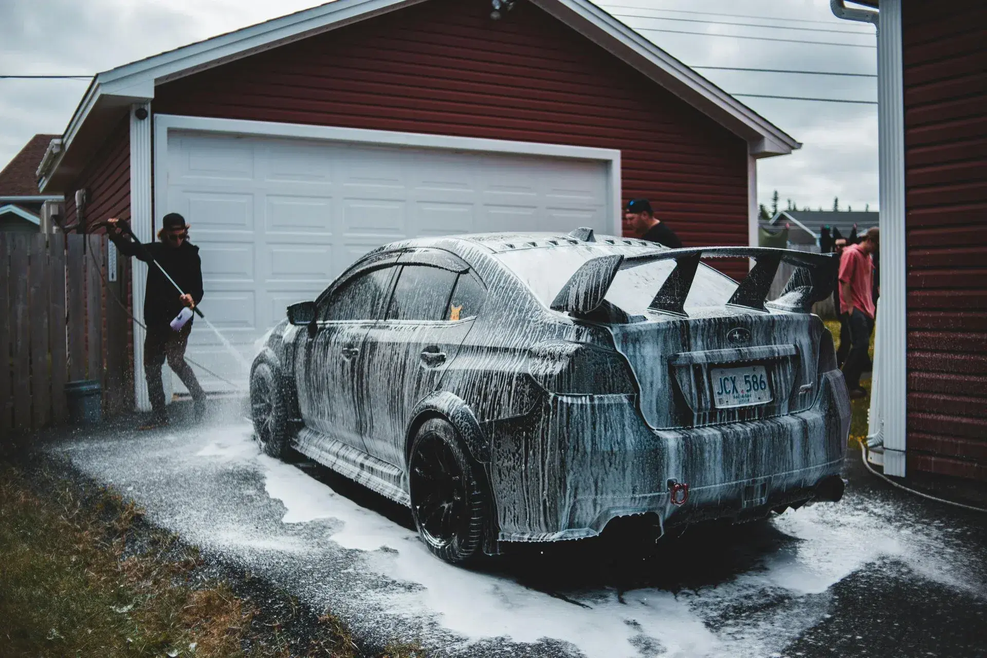 A detailer polishing the hood of a car with a foam pad