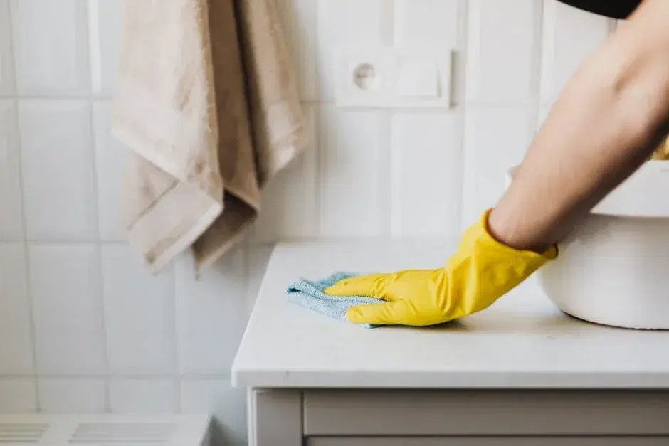 A person relaxing with coffee while a professional cleaner works in the background