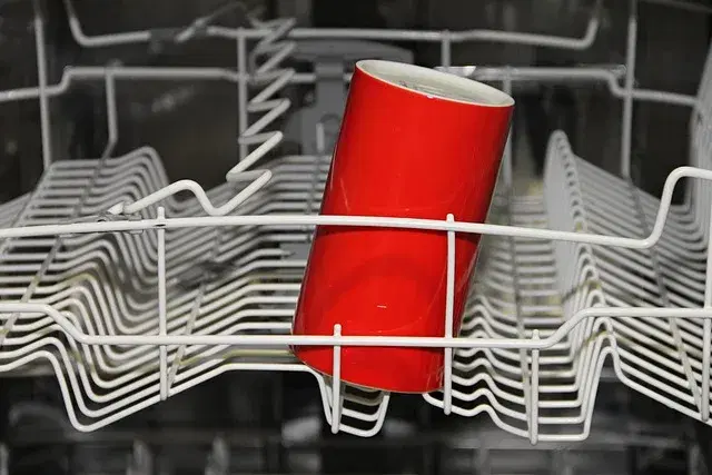 Dishwasher rack loaded with clean dishes and cup