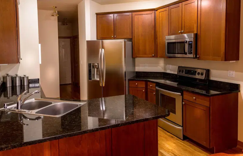 Stainless steel kitchen appliances - fridge, stove, and microwave