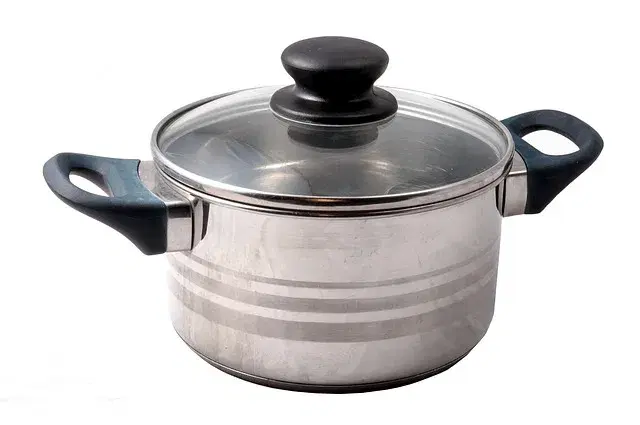 Stainless steel pot on a kitchen stove being cleaned