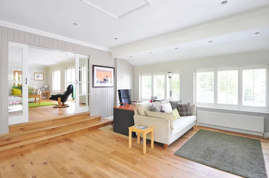 Bright, freshly cleaned living room with hardwood floors and a white sofa