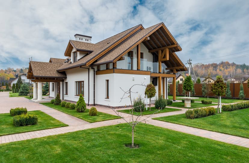 house with a green lawn and white/brown exterior