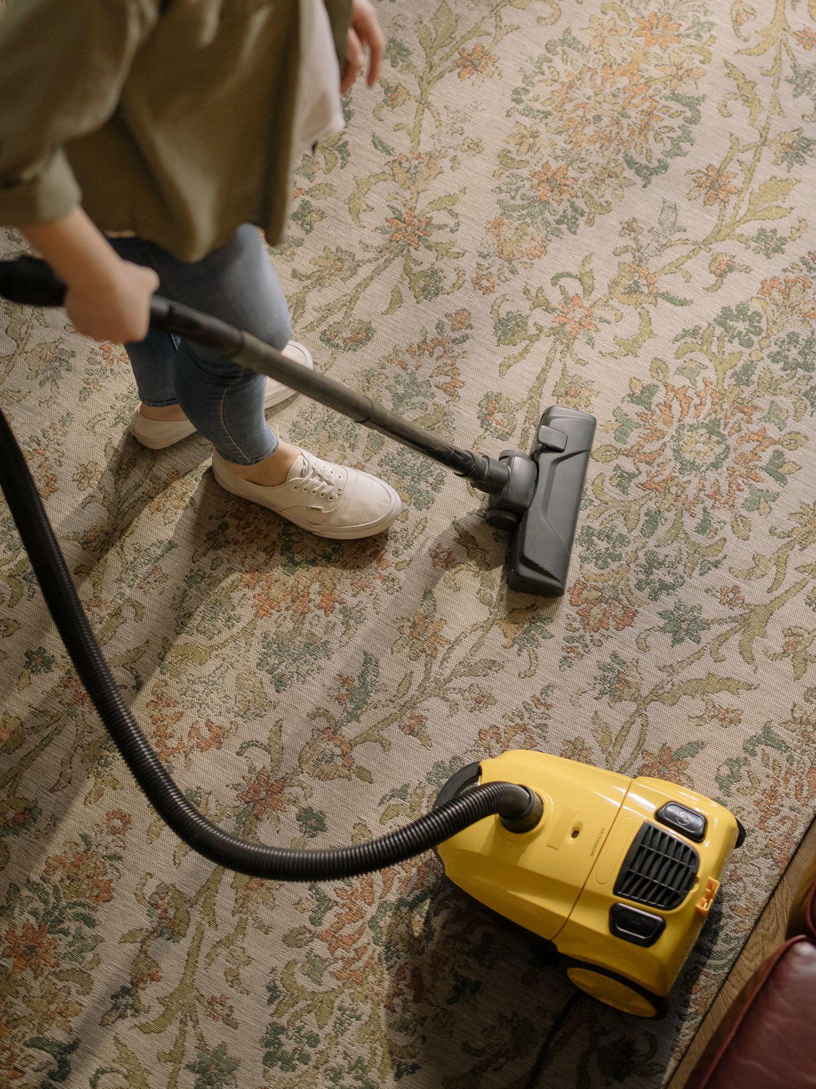 Person mopping hardwood floors with a microfiber mop in a bright home