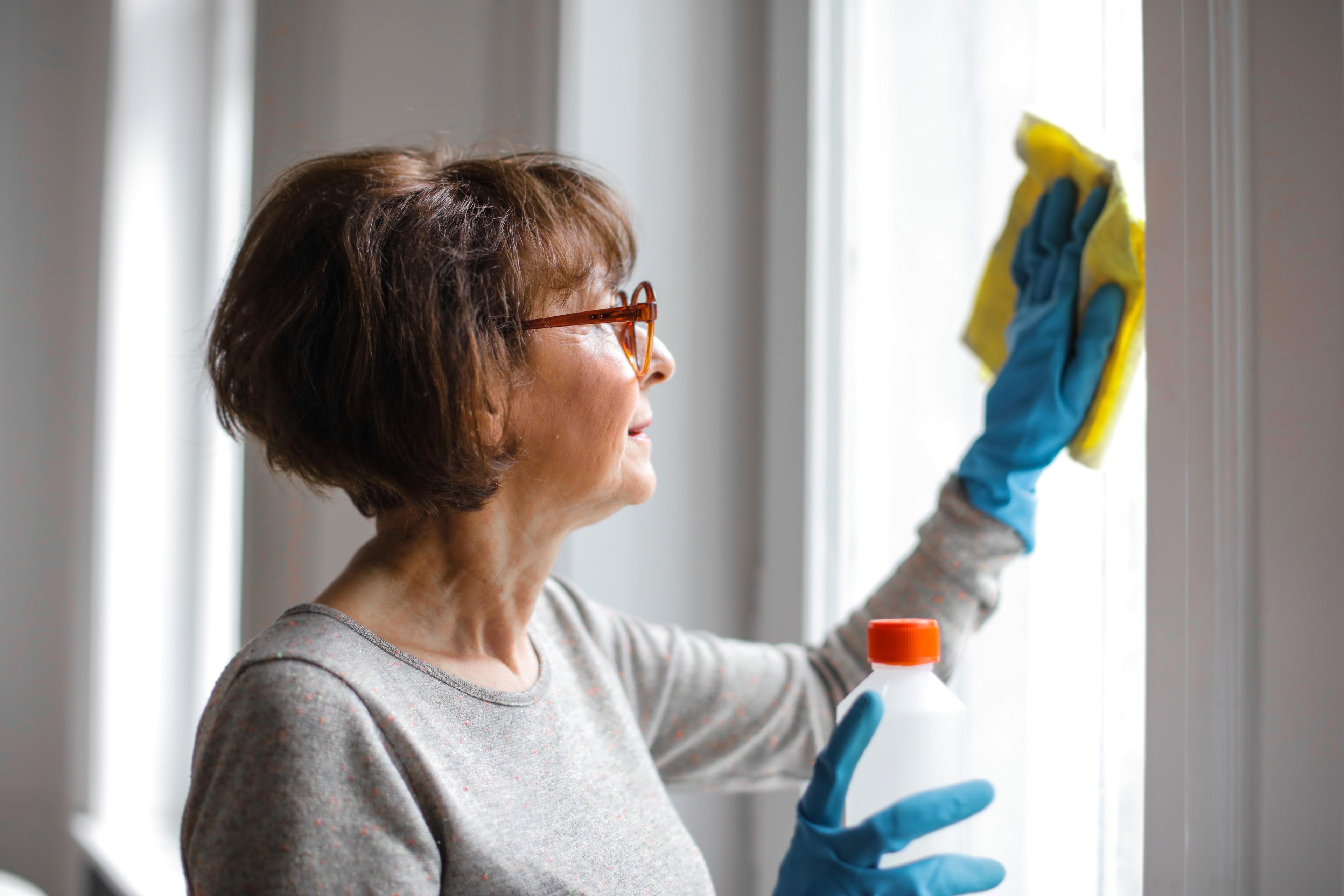 a woman cleaning windows by wiping
